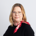 Katja Creutz. Red scarf, black shirt, brown hair, big glasses,