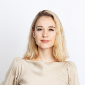 Portrait of Tyyne Karjalainen, blode hair, dark eyes, beige shirt.