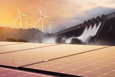 A renewable energy scene with solar panels, wind turbines, and a hydroelectric dam under a sunset sky.