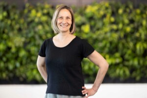 Karoliina Anttonen smiling at the camera with her hands on her waist and a black t-shirt on.