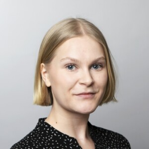 Emma looking at the camera, short blonde hair and a black blouse.