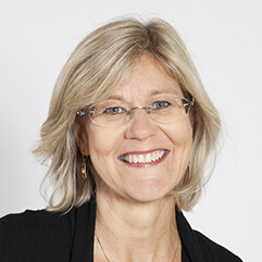 Mar-Leena Kolehmainen smiling at the camera, short blonde hair and a black blouse.