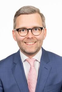 Mats Löfström looking at the camera with a blue suit on, white background.