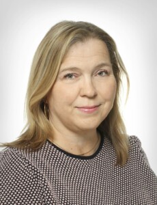 Marjo nummelin looking at the camera. Blonde, short hair and a black-and-white blouse.