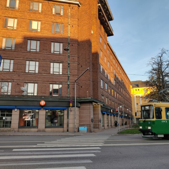 Arkadiankatu during sunset. A tram passes a brick building.