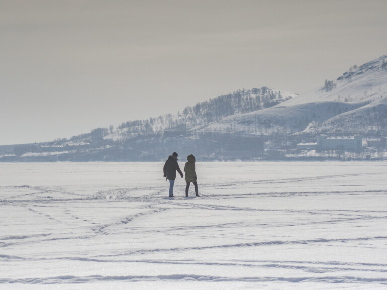 Winter landscape: an icy lake surrounded by mountains