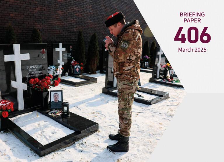 Cover photo for the publication. A veteran in military attire lights a cigarette beside a grave at the Alley of Fame cemetery in Istra, Moscow region, on February 7, 2025.