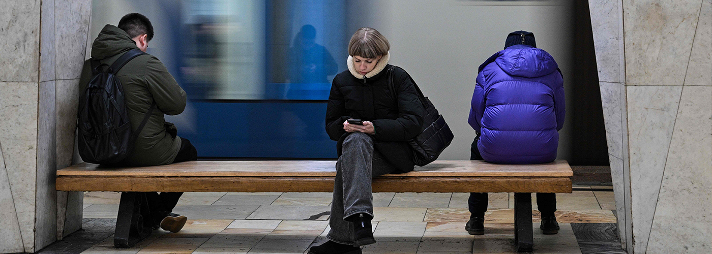 People scroll on their phones in a metro station in Moscow.