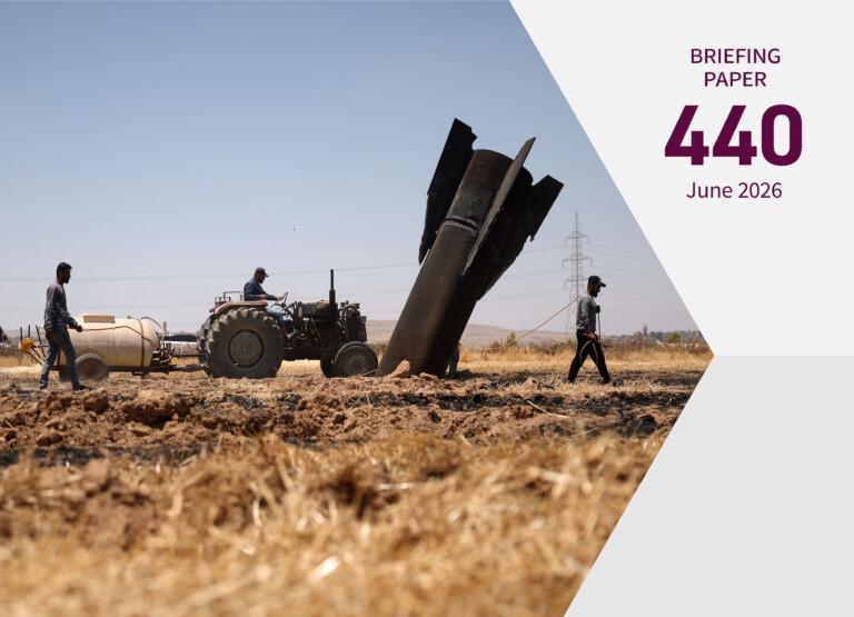 Cover image; two people walking and one driving a tractor on a burned agricultural field next to a large projectile sticking out from the ground.