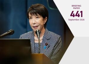 Cover of the publication; Prime Minister Sanae Takaichi speaking into a microphone, wearing a blue suit with white polka dots.