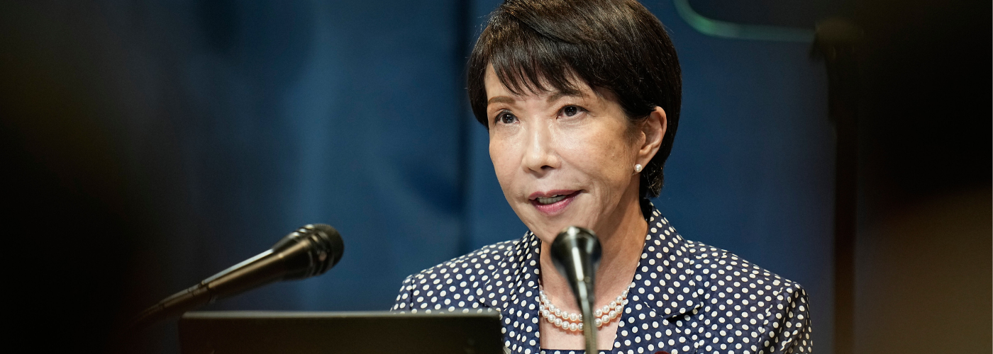 Japanese Prime Minister Takaichi speaking into a microphone.