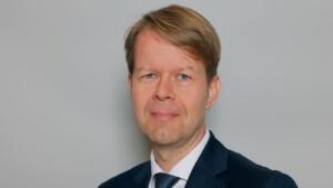 Portrait of a man with blond hair dressed in a suit.