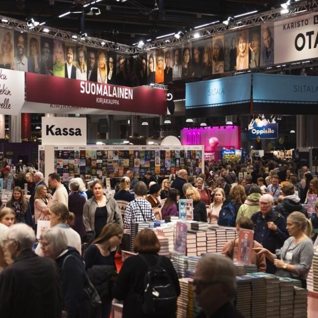 A crowd of people among bookshelves at Kirjamessut in Helsinki.